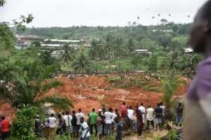 People look at the site of a landslide that killed at least 13 people in Anyama, a suburb of Abidjan.. By SIA KAMBOU (AFP)