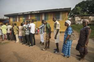 People line up to vote at a polling station in Kibi, southern Ghana, on December 7, 2016