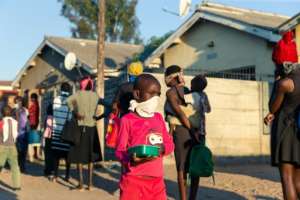 People queue in Chitungwiza for hot meals. By Jekesai NJIKIZANA (AFP/File)