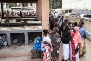 People wait in line ahead of a polling booth opening in a market in the Banjul neighbourhood of Manjai Kunda. By JOHN WESSELS (AFP)