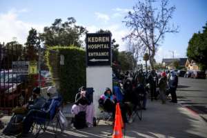People without appointments wait in line for the potential chance to receive a Covid-19 vaccination that would have otherwise been discarded at the Kedren Community Health Center on January 25, 2021 in Los Angeles. By Patrick T. FALLON (AFP)