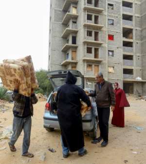 People unload donated furniture for displaced families. By Mahmud TURKIA (AFP)