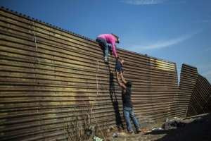 Pedro Pardo, based in Mexico City, was nominated for this photo of migrants scaling the border fence between Mexico and the United States. By Pedro PARDO (AFP/File)