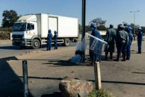 Police ask for travel documents at a road block in Mbare, a township in the suburbs of Harare. By Jekesai NJIKIZANA (AFP)