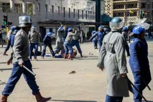 Police beat a protester in a public square in Zimbabwe's capital Harare. By Zinyange Auntony (AFP)