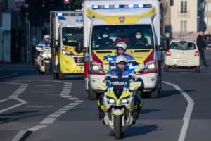 Police officers escort an ambulance carrying patients infected with the covid-19 disease in Nantes, France. By Loic VENANCE (AFP)