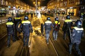 Police officers patrol the streets of Rotterdam a day after clashes with demonstrators protesting against new Covid-19 restrictions. By STR (ANP/AFP)