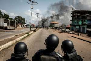 Plumes of black smoke rose over an opposition stronghold in the capital Conakry, where protesters erected barricades and lit fires. By JOHN WESSELS (AFP)