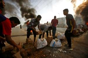 Protesters build a brick barricade on Street 60, one of the main streets in the capital. By ASHRAF SHAZLY (AFP)