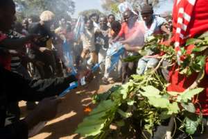 Protesters burns shirts and flags from the recently re-elected Malawian president Arthur Mutharika's Democratic Progressive Party as part of the demonstrations in Lilongwe. By AMOS GUMULIRA (AFP)