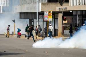 Protesters rushed for cover as police fired tear gas. By Zinyange Auntony (AFP)