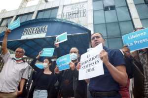 Protesters stand outside the offices of the Algerian newspaper Liberté on April 25, 2021, calling for the release of journalist Rabah Kareche.  By - (AFP)