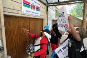 Protestors hammer the doors of The Gambia's consulate in Beirut demanding to be evacuated back to their country. By ANWAR AMRO (AFP)