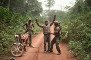Rangers search a motorcycle taxi for pangolin scales or ammunition. By FLORENT VERGNES (AFP)