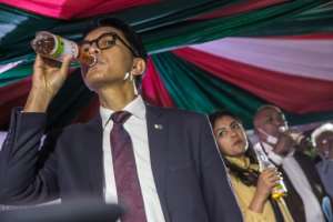 Rajoelina drinks from a bottle of Madagascar's self-proclaimed herbal remedy for coronavirus, Covid-Organics. By RIJASOLO (AFP)