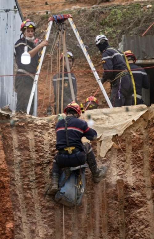 Red-helmeted Civil Defence workers have at times been suspended by rope, as if on a cliff face.  By Fadel SENNA (AFP)