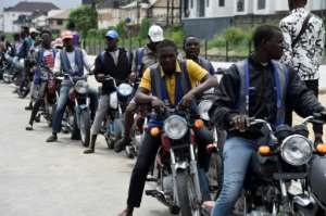 Regular motorcycle taxis queue for custom in Lagos -- helmets and safety kits are absent, and passengers have to haggle over fares. By PIUS UTOMI EKPEI (AFP)
