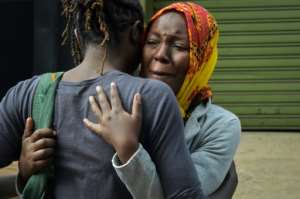 Relatives sob as they identify the bodies of the victims of the bomb and gun attack on a hotel complex in Kenya.  By SIMON MAINA (AFP)