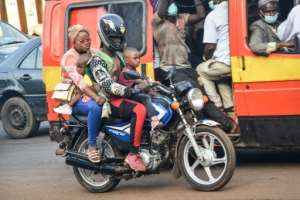 Risky ride: A woman and two young boys take a motorcycle taxi in Conakry. By CELLOU BINANI (AFP)