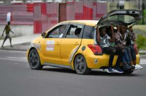 Room for one more? People sit in the boot, or trunk, of a taxi driving through Kinshasa. By TONY KARUMBA (AFP)