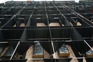 Rows of beds separated by black fabric are set up as a temporary field hospital for COVID-19 patients at the USTA Billie Jean King tennis center in New York. By Bryan R. Smith (AFP)
