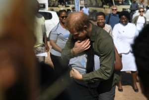 Royal embrace: The prince gives a youngster a hug at a charity for vulnerable children in Sentebale. By MONIRUL BHUIYAN (AFP)