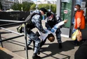 Russian National Guard (Rosgvardia) officers detain a man in front of a supermarket in Moscow after city authorities made it mandatory to wear gloves and a mask in pubic places. By Alexander NEMENOV (AFP)