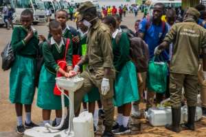 Secondary school students wash their hands at temporary hand washing point in Rwanda. By STRINGER (AFP)