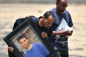 Some mourners carried pictures of their loved-ones. By TONY KARUMBA (AFP)