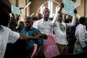 Some worshippers at Friday's mass held up protest banners
