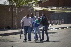 South African police officers detained looters after the outbreak of rioting in the Johannesburg township of Alexandra. By GUILLEM SARTORIO (AFP)