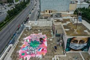 Spraypainted graffiti, inspired by the COVID-19 novel coronavirus, on the roof of the artist's apartment building in Athens. By Aris Messinis (AFP)