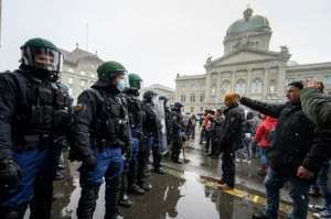 Swiss voters firmly backed a proposed Covid pass law in a referendum despite protest fears. By Fabrice COFFRINI (AFP)