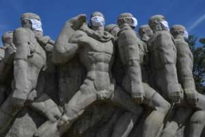 Statues of the Monumento das Bandeiras wear face masks in Sao Paulo, Brazil. By NELSON ALMEIDA (AFP)