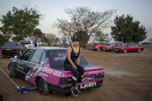 Stacey-Lee May, who has gained international fame for her stunts, poses on her car.  By Michèle Spatari (AFP)