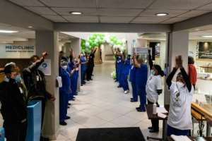 Staff sing and cheer after the arrival of Rodwell Khomazan at the Mediclinic Sandton Hospital where he will undergo surgery to reconstruct his face. By GUILLEM SARTORIO (AFP)