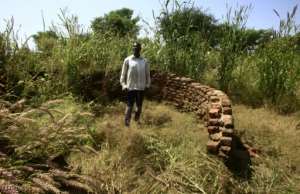 Sudanese villager Siddiq Youssef checks the remains of his house which was burnt 15 years ago in the village of Shattaya one of several in the Darfur region that faced the brunt of the attack unleashed by the notorious Janjaweed militia. By ASHRAF SHAZLY (AFP)
