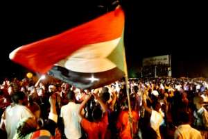 Sudanese wave flags and chant slogans as they gather during a demonstration outside the army headquarters in Khartoum on May 30, 2019. By ASHRAF SHAZLY (AFP/File)