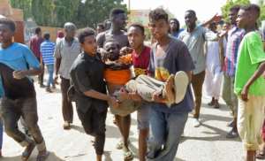 Sudanese carry a man injured during clashes as part of protests against a military coup on October 25. By - (AFP)