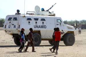 Sudanese children walk past an armoured vehicle of the United Nations and African Union peacekeeping mission (UNAMID) in Kalma Camp for internally displaced people in Nyala, the capital of South Darfur, on Wednesday. By - (AFP)