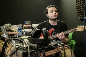 Sudanese music producer and guitarist Amjad Badr plays the guitar at Capital Radio in Khartoum. By Yasuyoshi CHIBA (AFP)