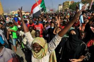 Sudanese protesters lift national flags as they rally on 60th Street in the capital Khartoum. By - (AFP)