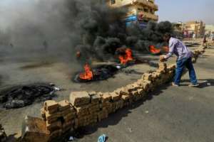 Sudanese protesters place bricks across a street in the capital Khartoum. By - (AFP)