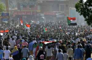 Sudanese protesters raise national flags during a demonstration calling for a return to civilian rule in the capital's twin city of Omdurman on November 21. By - (AFP)