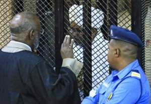 Sudan's deposed military president Omar al-Bashir sits in a defendant's cage during his corruption trial at a court in Khartoum on December 14, 2019. By - (AFP/File)