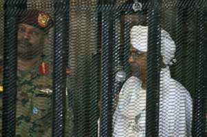 Sudan's deposed military ruler Omar al-Bashir stands in the defendant's cage during the opening of his corruption trial in Khartoum, an image that instantly became a symbol of his Islamist military regime's downfall in the face of popular protests. By Ebrahim HAMID (AFP)