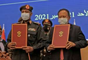 Sudan's top general Abdel Fattah al-Burhan (L) and Prime Minister Abdalla Hamdok lift documents during a deal-signing ceremony on November 21. By - (AFP)