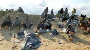 Survivors sit on the shore in Khoms on Thursday. The IOM said that so far this year, at least 900 people had drowned in the Mediterranean trying to reach European shores. By - (AFP)