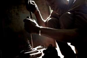 Surgery: A Bamako mechanic takes apart an old Vespa engine. By MICHELE CATTANI (AFP)