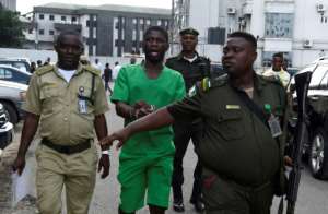 Suspected serial killer Gracious David-West, centre, being led into court on November 18. By PIUS UTOMI EKPEI (AFP)